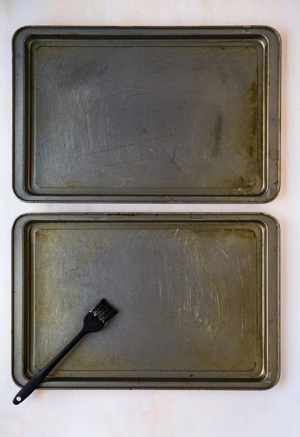 Baking trays being lightly greased with butter before making Scottish Shortbread.