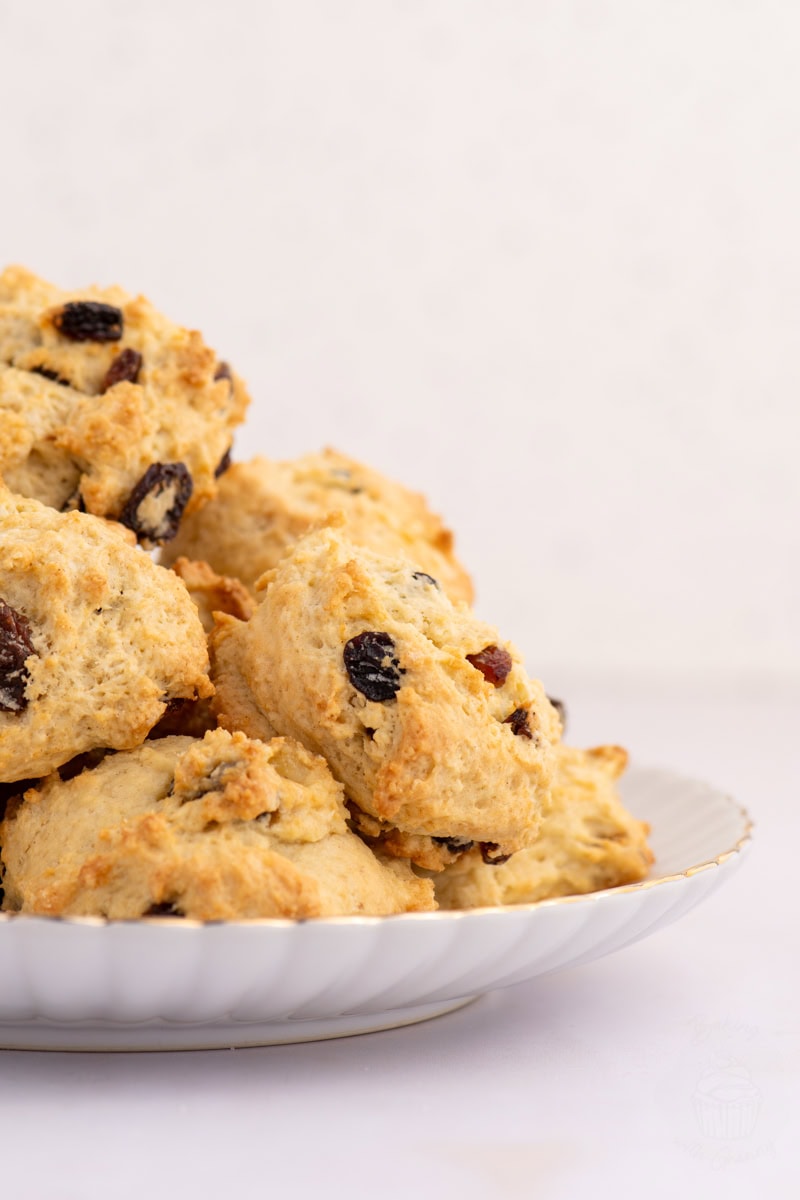 Plate stacked with homemade Rock Buns filled with dried mixed fruit.