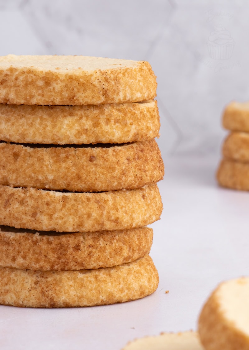 Close-up of a stack of Highlander Shortbread biscuits with crisp golden edges rolled in sugar.