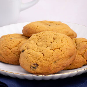 Stack of golden Coffee Buns on a plate with a cup of coffee in the background.