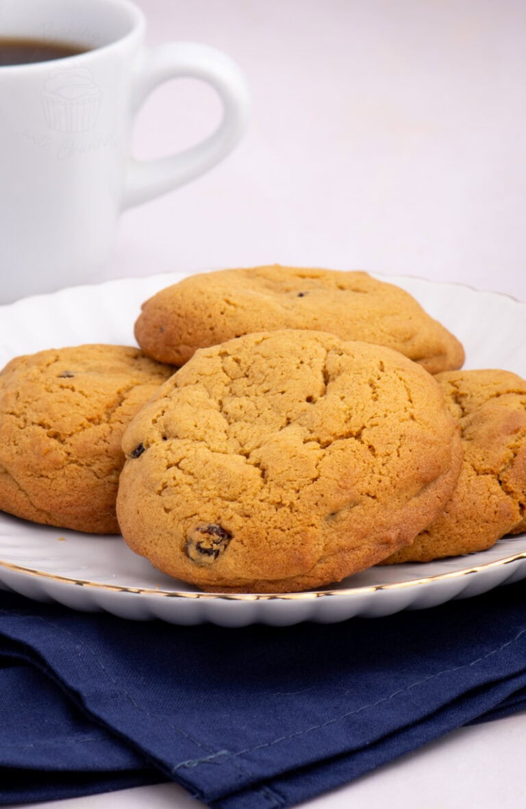 Stack of golden Coffee Buns on a plate with a cup of coffee in the background.