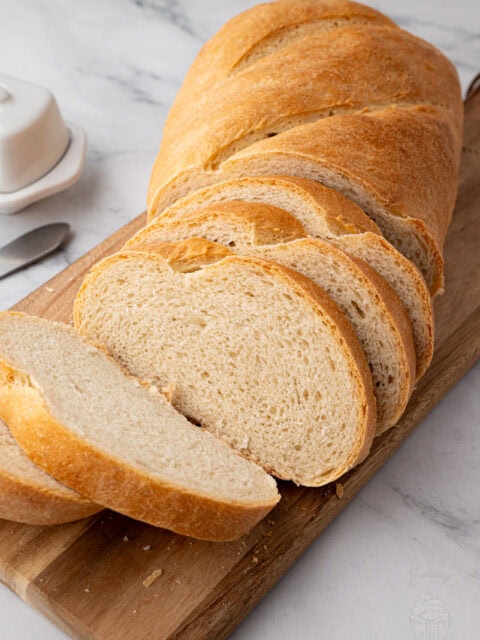 Several slices of homemade white bread cut from a fresh loaf.