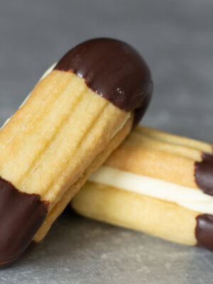 Recipe for easy Viennese biscuits. Buttery biscuits, dipped in chocolate and sandwiched with buttercream.
