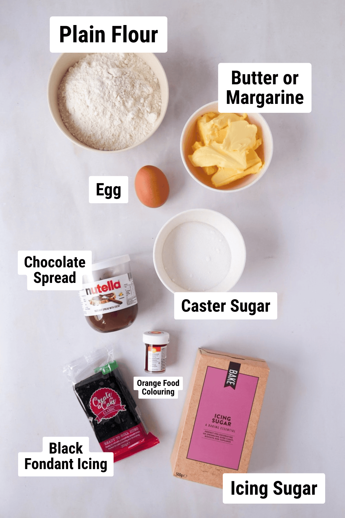 Ingredients for Pumpkin Empire Biscuits, including flour, butter or margarine, egg, caster sugar, chocolate spread, orange food colouring, black fondant icing and icing sugar.