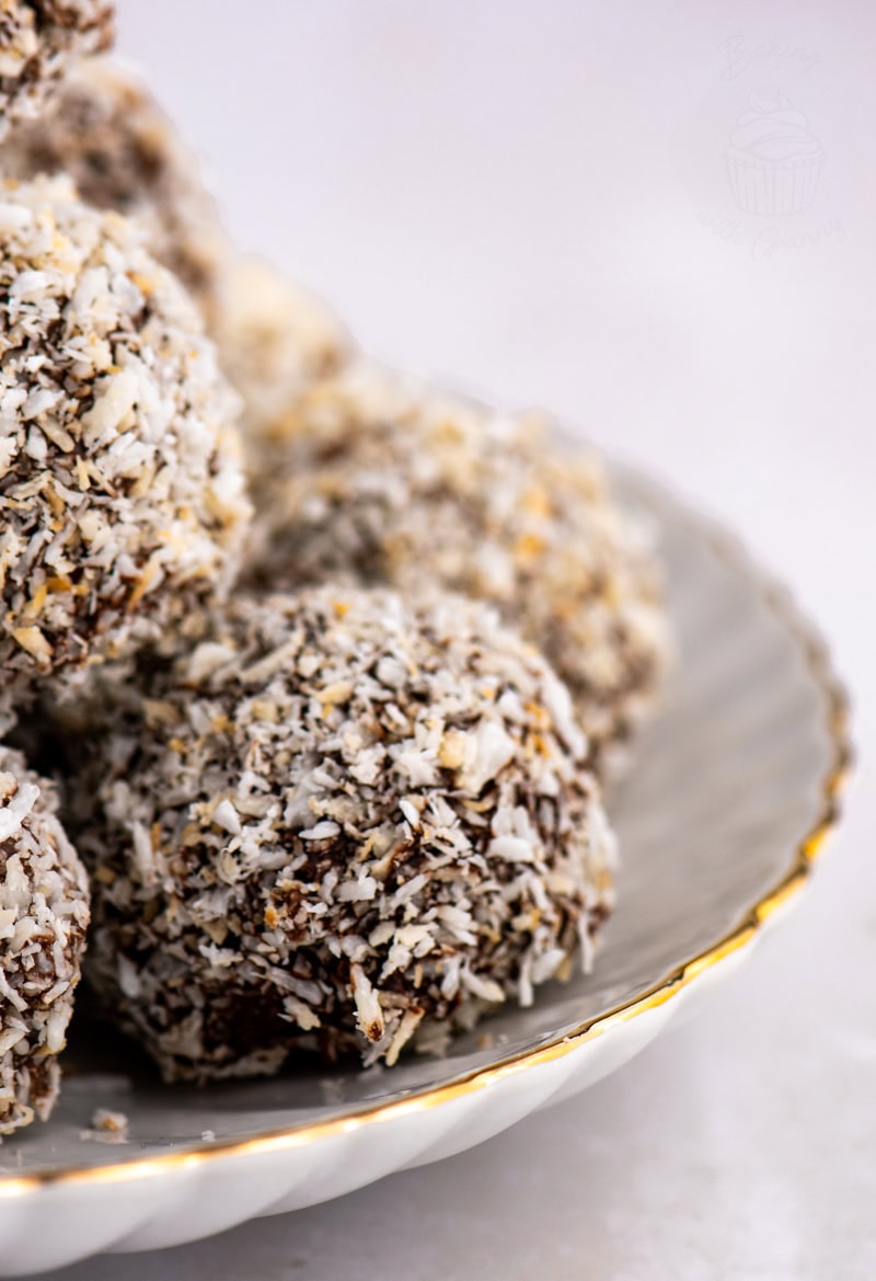 Close-up of traditional Scottish Macaroons coated in chocolate and desiccated coconut on a plate.