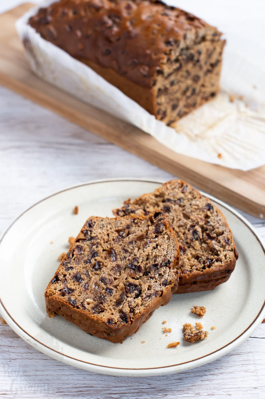 Slices of Bara Brith cake on a plate, with the loaf behind.