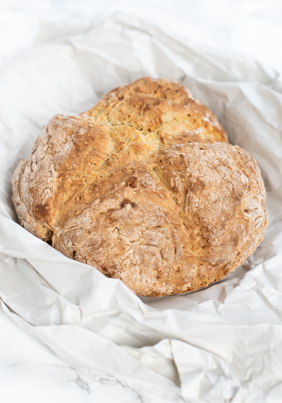 Freshly baked Irish soda bread loaf with crisp golden crust, part of an easy traditional soda bread recipe.