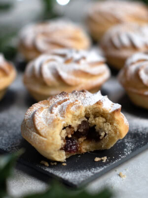 Sweet mince pies, made with shortcrust pastry, juicy mincemeat, and topped with a Viennese whirl.