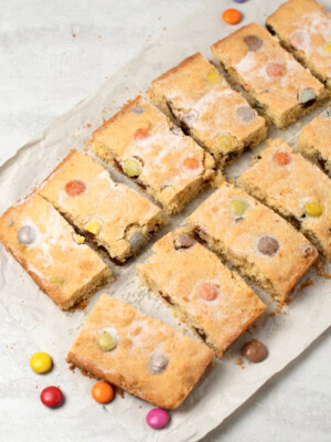 Polka Dot Slice recipe from Baking with Granny. Easy tray bake cake for kids, made with coconut and rainbow chocolate drops (such as Smarties or M&Ms).