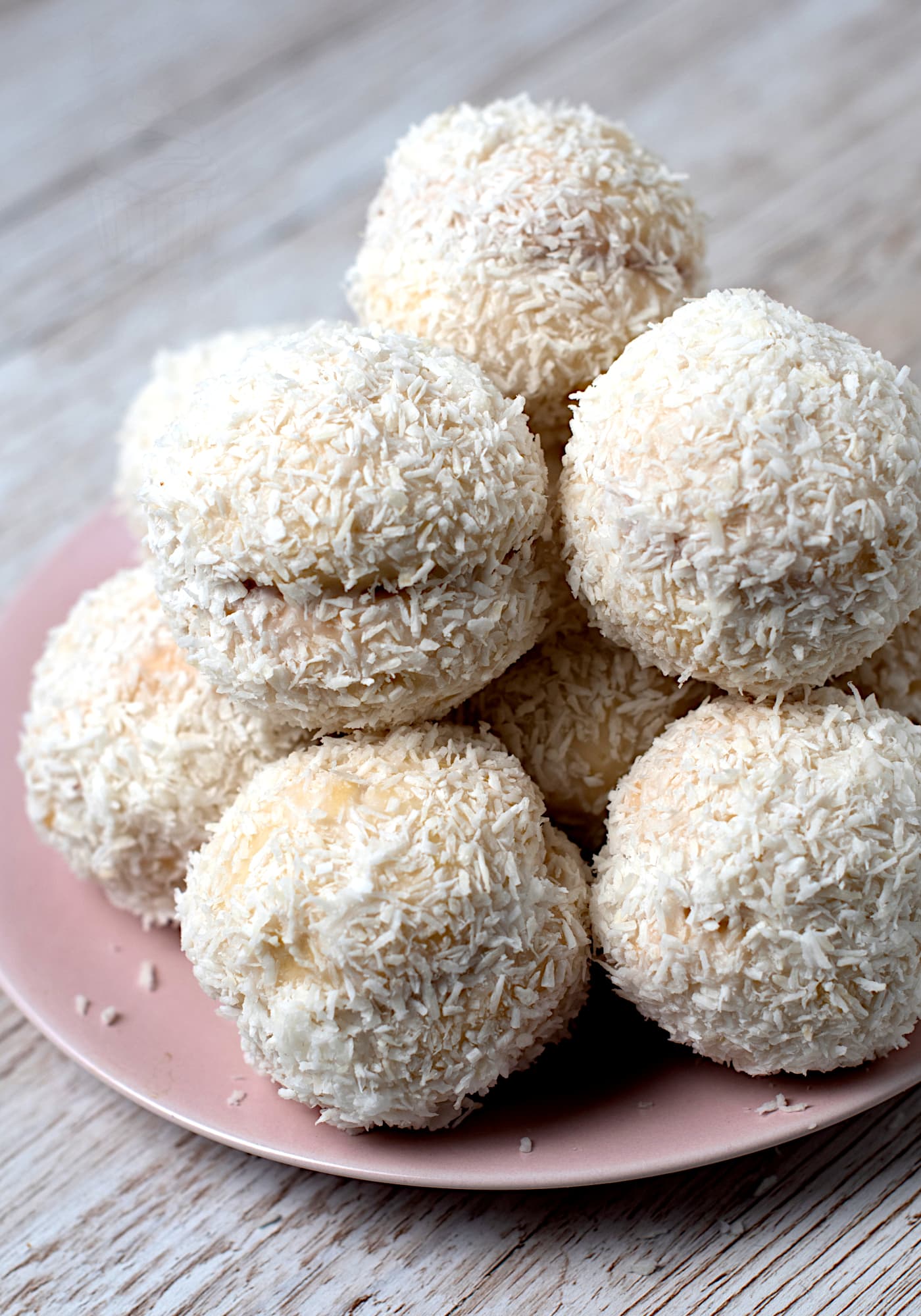 Plate of homemade Scottish Snowballs (Snowy Joeys) coated in icing and rolled in desiccated coconut.