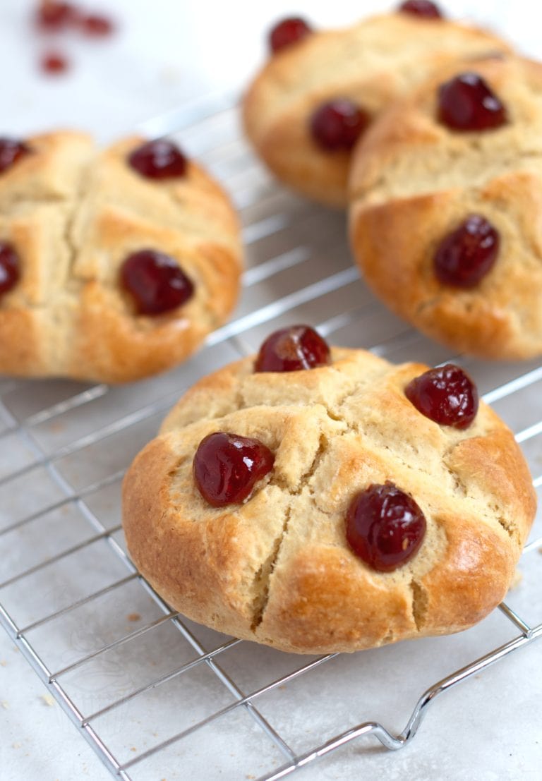 Victoria Scones on a wire rack. Freshly baked golden scones, finished with a cross and glace cherries.