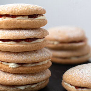 Small stack of Sponge Drop cakes, sandwiched together with fresh cream and strawberry jam. More Sponge Drops can be seen around the stack.