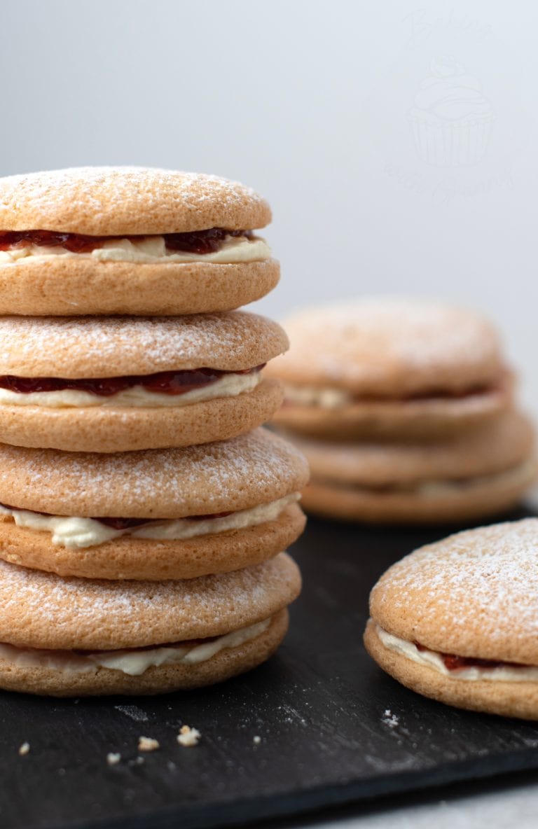 Small stack of Sponge Drop cakes, sandwiched together with fresh cream and strawberry jam. More Sponge Drops can be seen around the stack.