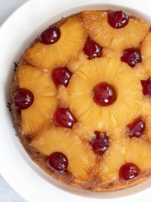 Upside-down Pineapple Cake, with golden pineapple rings, dotted with red glace cherries.