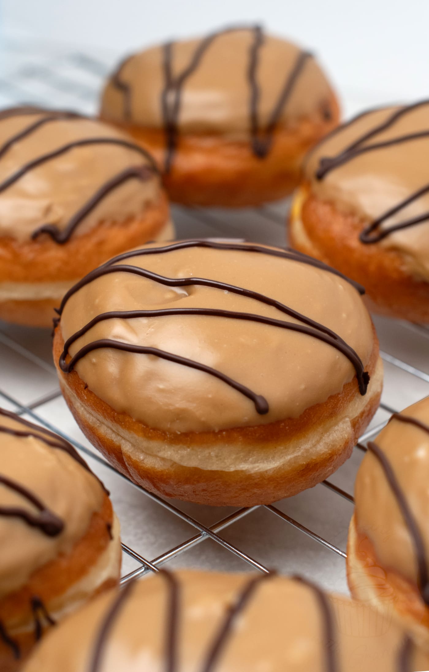 Fudge doughnuts recipe. Soft doughy buns, filled with delicious custard and topped with freshly made sweet fudge icing.