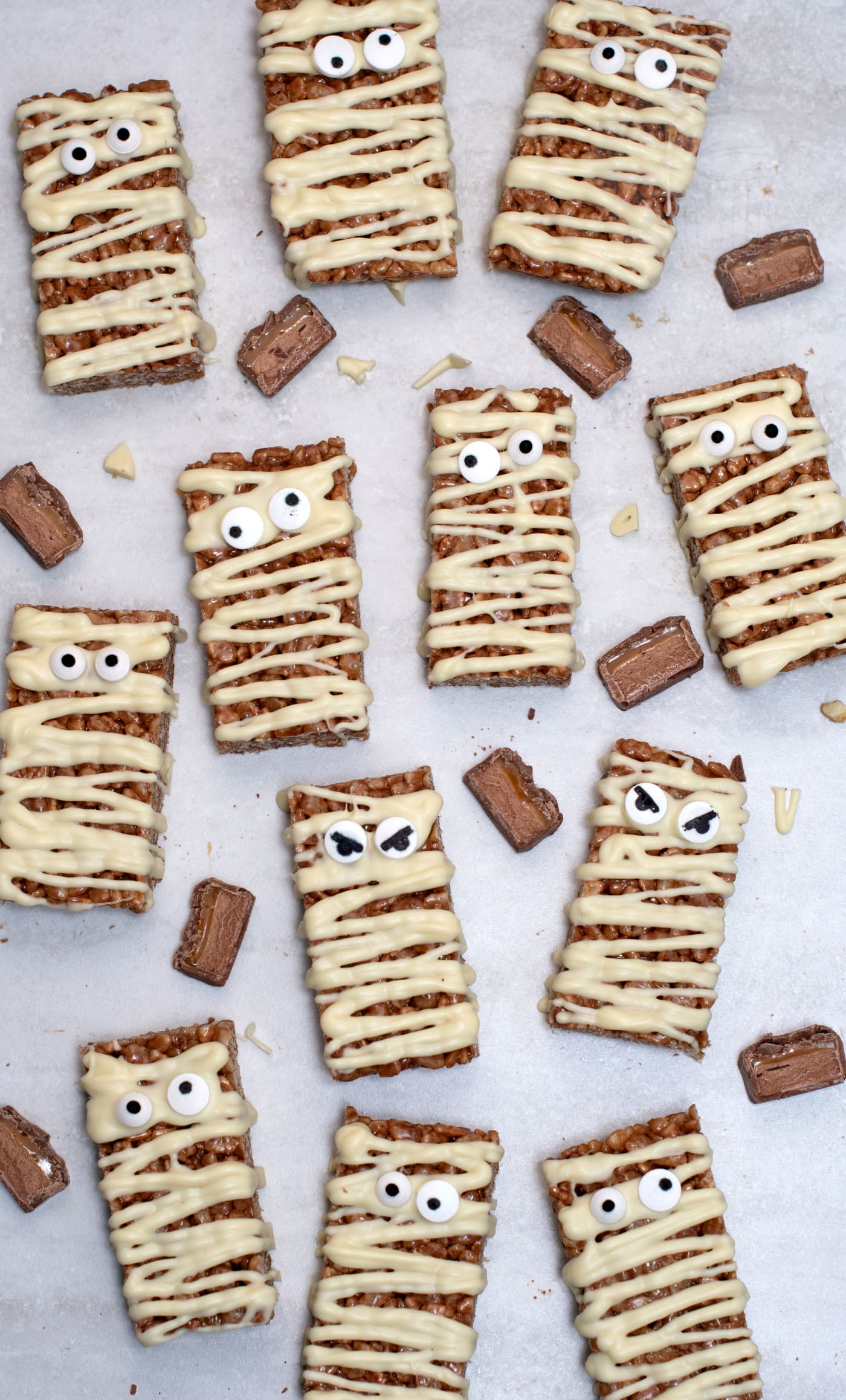 Mummy Mars Bar slices decorated with white chocolate bandages and candy eyes, a fun Halloween twist on a classic Mars Bar slice.