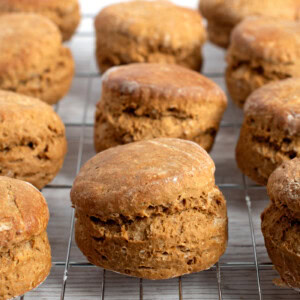 Freshly baked Scottish treacle scones cooling on a metal rack against a light background.