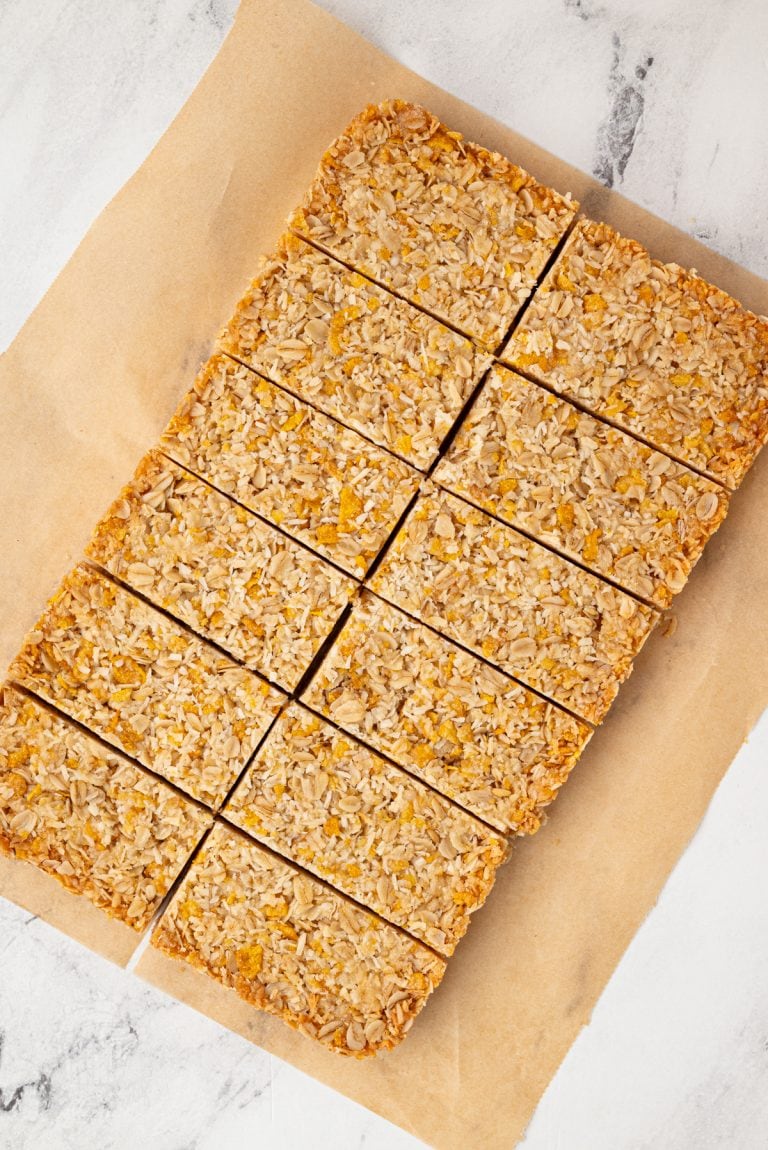 Overhead view of a full tray of honey slice cut into even bars on brown parchment paper.