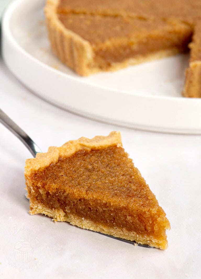 Individual slice of British treacle tart with visible syrupy filling and crumbly pastry. A simple and nostalgic UK dessert.