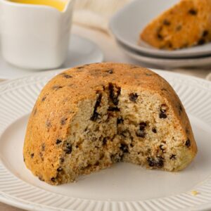Traditional spotted dick pudding dotted with dried fruit and served with custard.