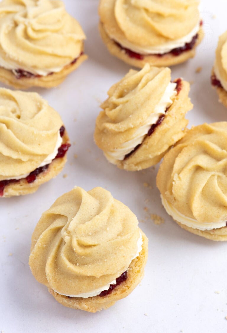 Selection of homemade Viennese Whirls biscuits with piped butter biscuit swirls sandwiched with jam and buttercream.
