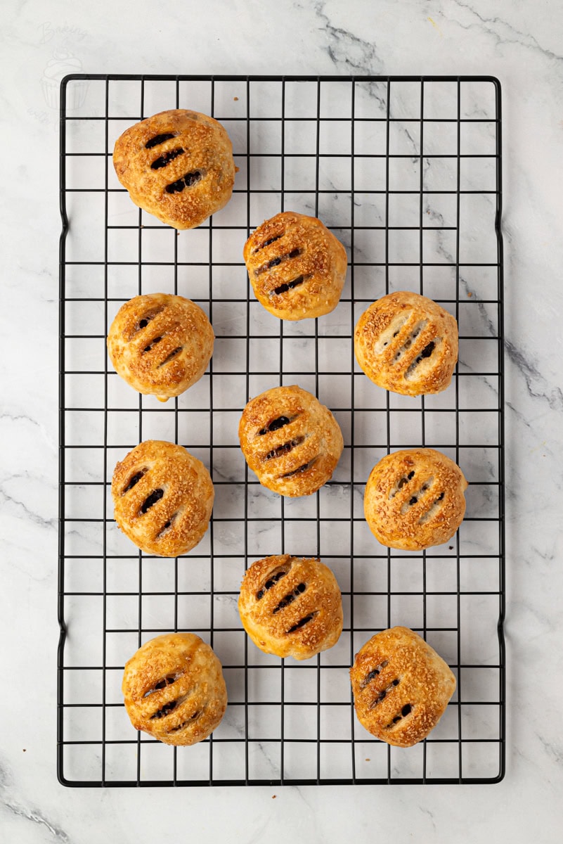 Freshly baked Eccles cakes cooling on a wire rack.