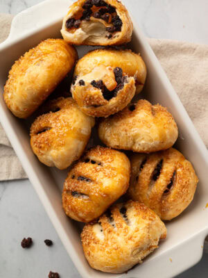 Eccles cakes served on a plate with one opened to show the fruit filling.