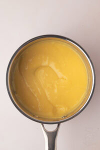 Thick homemade custard for Manchester Tart cooking in a saucepan until smooth and creamy.