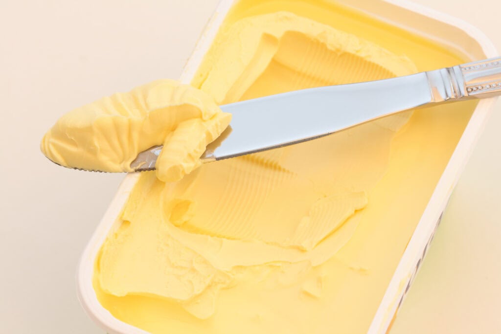 A tub of British baking margarine with a butter knife on top.