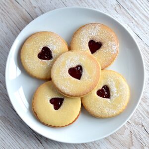 Homemade Jammy Dodgers sandwiched with red jam and heart-shaped centres.