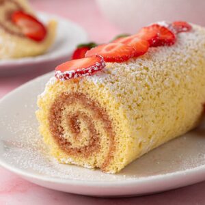 Sliced Swiss roll filled with jam, showing its spiral sponge centre.