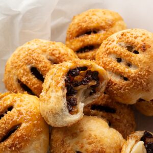 Eccles Cakes on a plate with one opened to show the fruit filling.