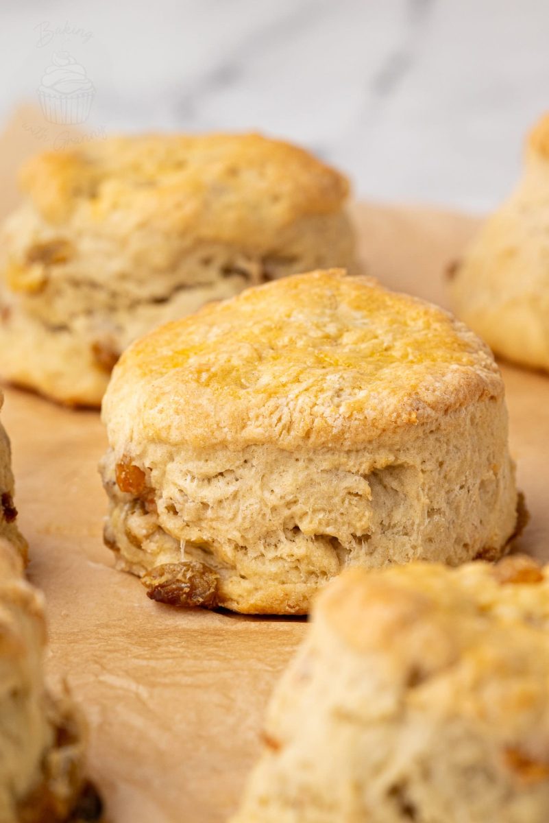 Close-up of a golden brown home baked Fruit Scones, fresh from the oven and cooling on baking parchment.