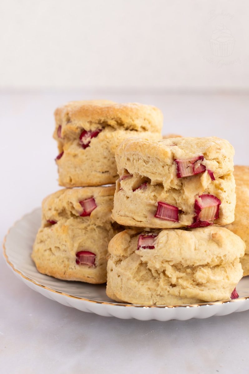 A view of stacked homemade Rhubarb Scones on a white plate with gold rim.