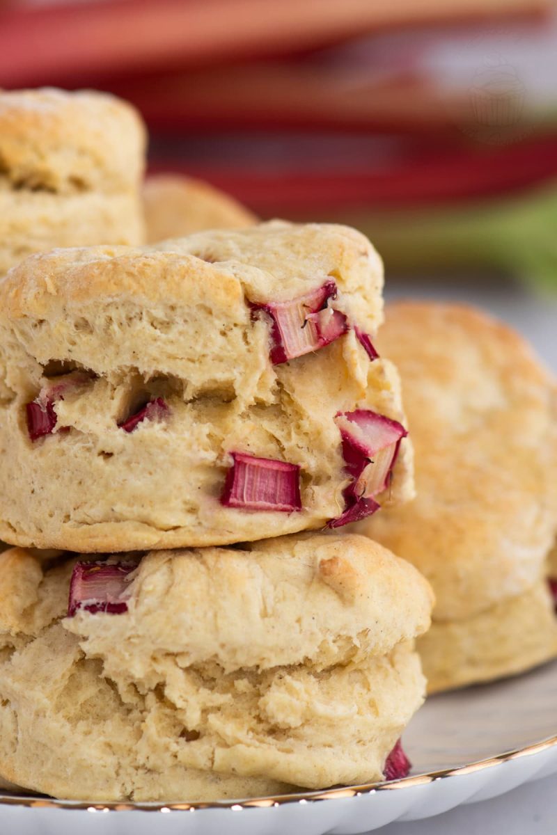 Close-up of Rhubarb Scones in a stacked pile, showing chunks of bright red seasonal rhubarb.